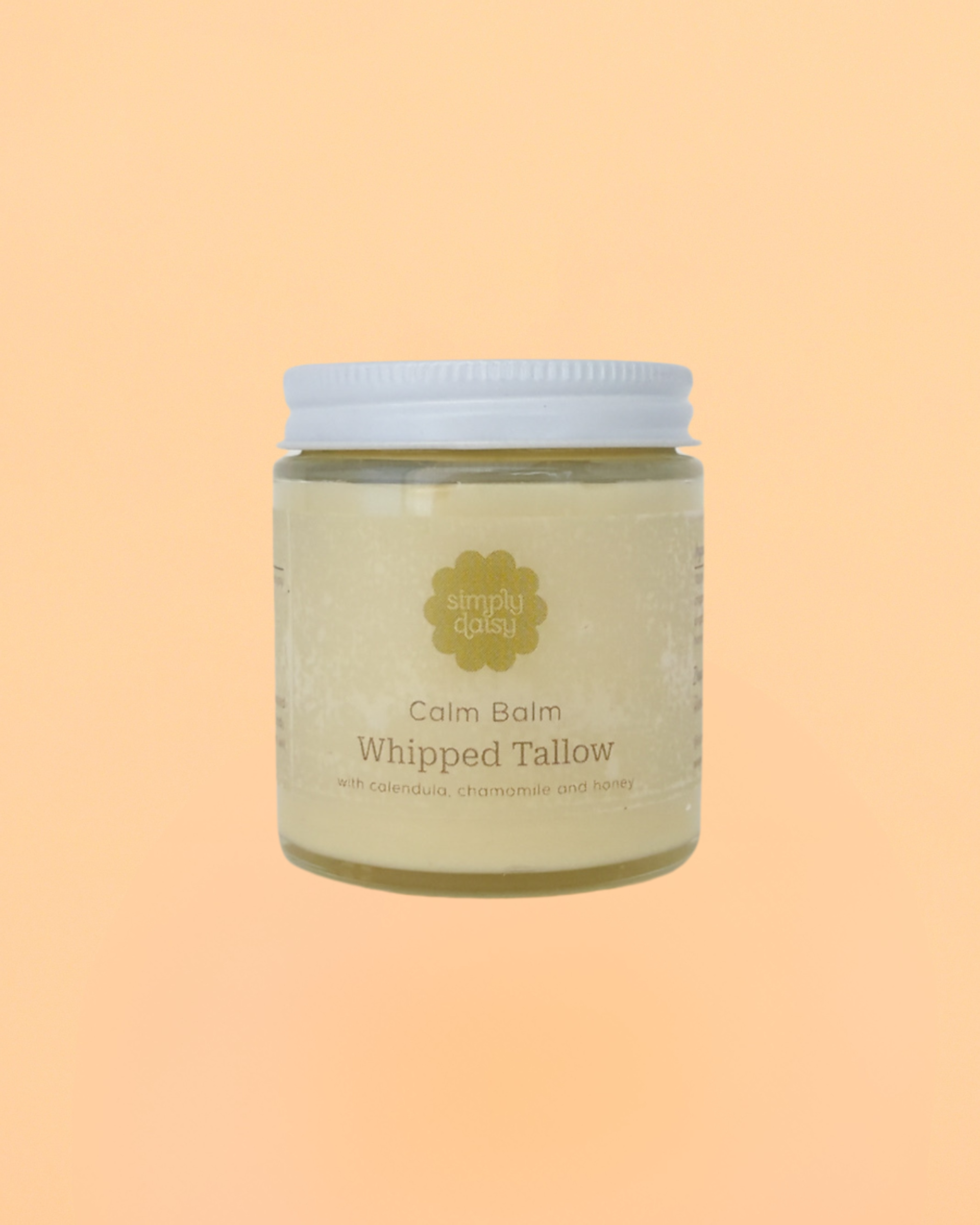 A glass jar of Calm Balm Whipped Tallow with a white label, containing a yellowish product, displayed against an orange background.
